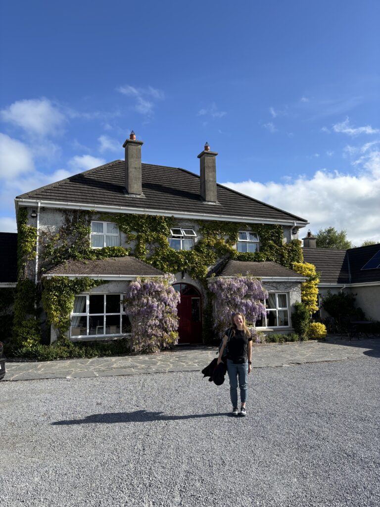 Adare Country House svečių namai ir jų kieme stovinti moteris