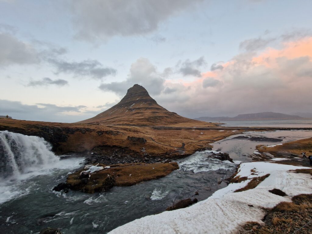 Tobulos piramidės formos kalnas Kirkjufell Islandijoje su šalia tekančiu kriokliu